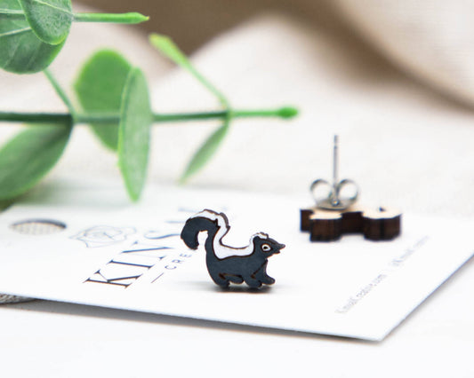Squirrel-shaped earrings on a card with green leaves in the background