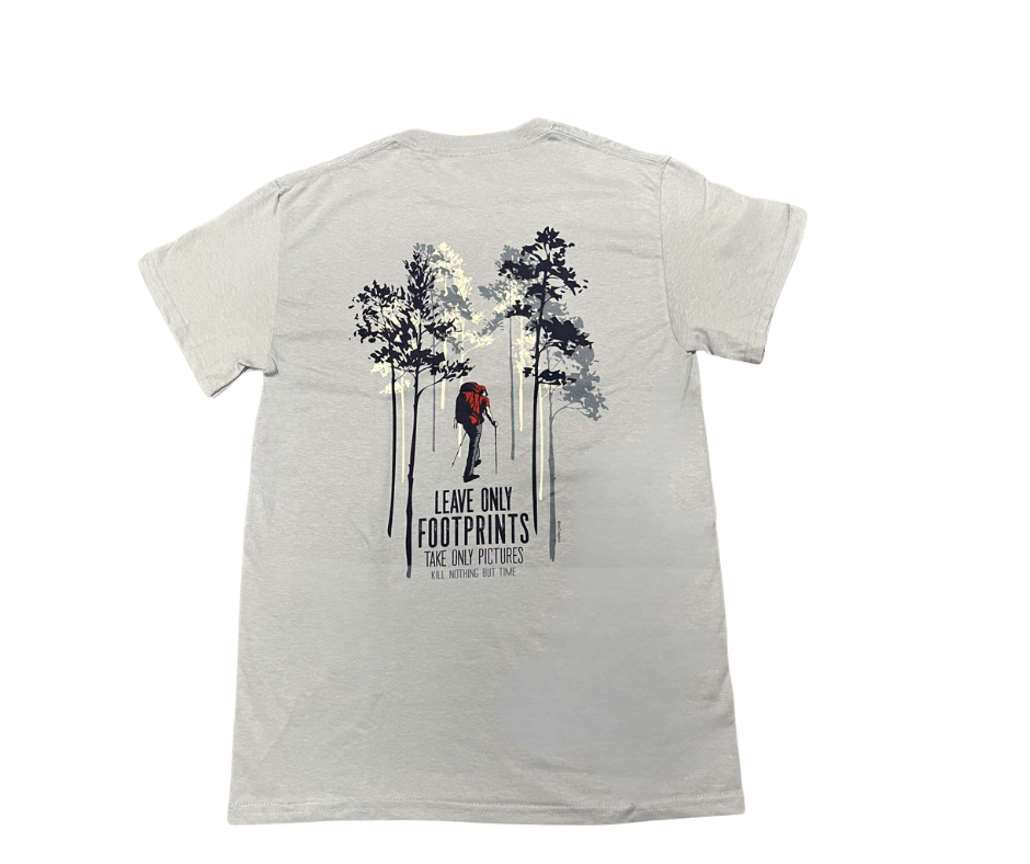 White t-shirt with a graphic of trees and a person hiking, with text 'Leave only footprints take only pictures' on a white background.