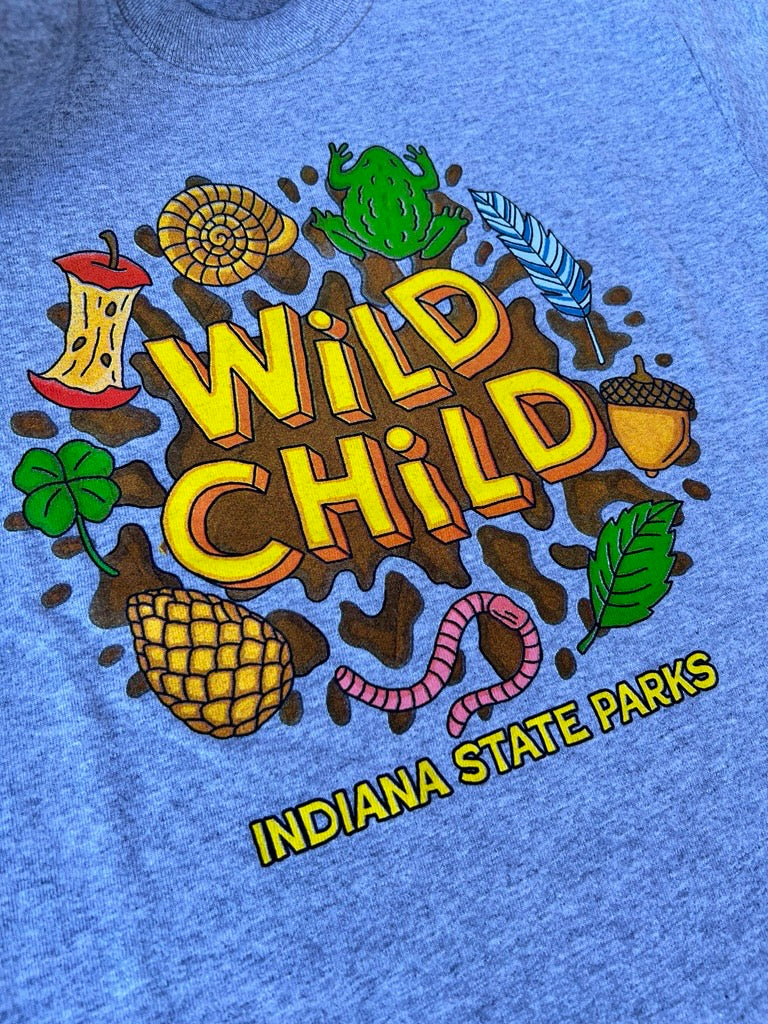 A gray short-sleeve youth t-shirt with a colorful 'Wild Child' graphic print, laid flat on a gray asphalt surface.