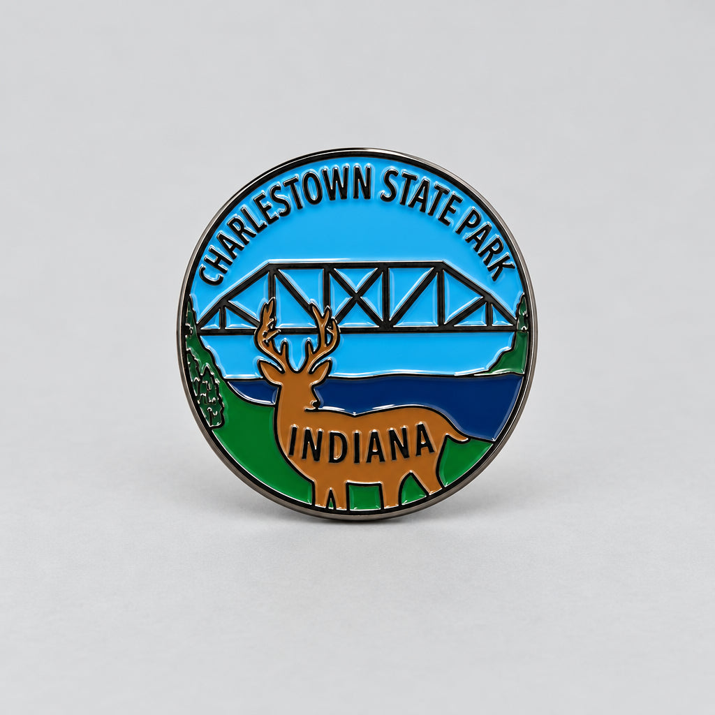 Charlestown State Park hiking stick medallion with an image of a deer and a bridge in the background.