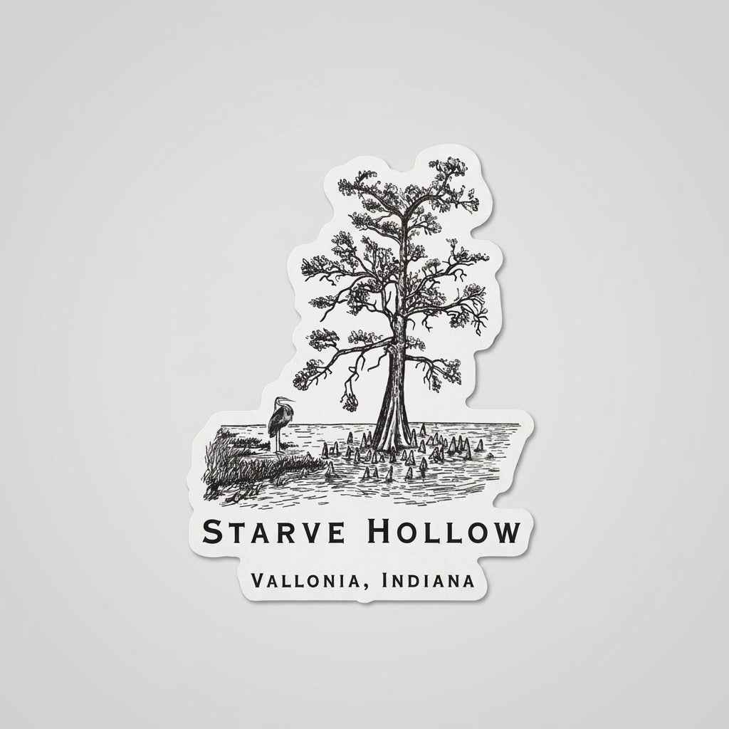 Black‑and‑white die‑cut sticker showing an illustrated tree by the water with surrounding vegetation and the text “Starve Hollow, Vallonia, Indiana.”