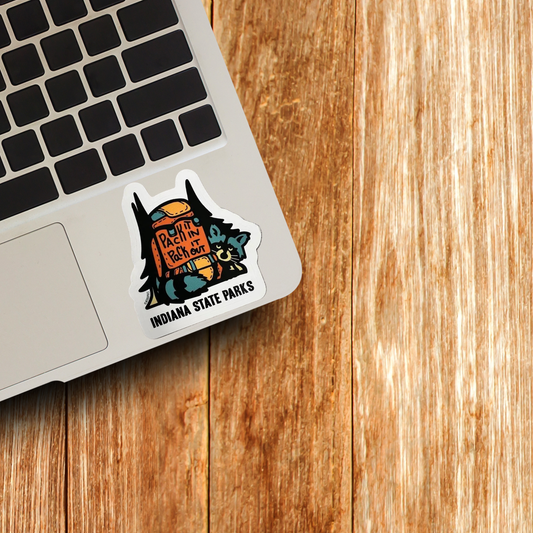 Sticker on a laptop keyboard with 'Indiana State Parks' text on a wooden surface