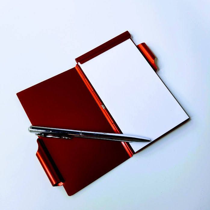 Red notebook with a white page on a white background