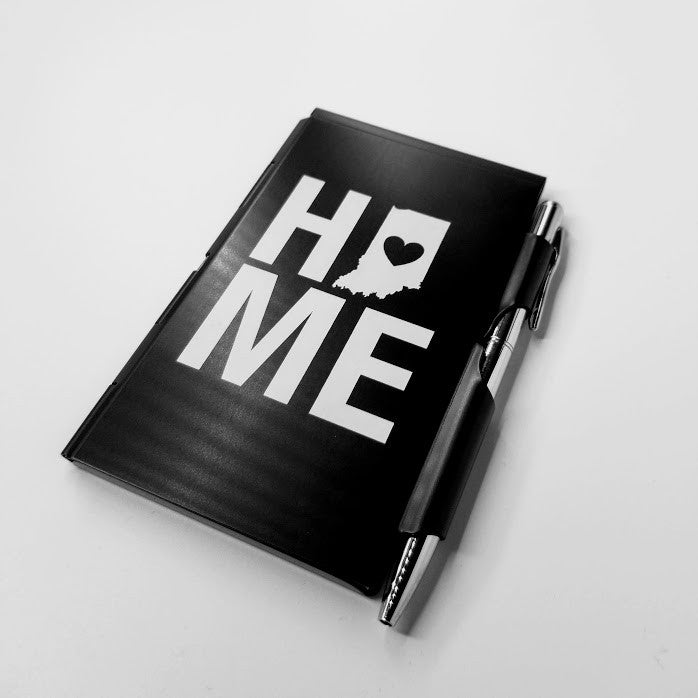 Black notebook with 'HOME' text and a heart on a white background