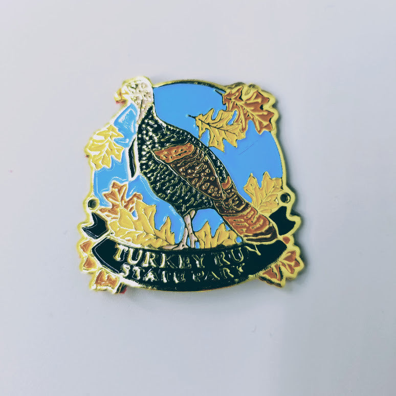 Hiking stick medallion with a turkey and leaves on a blue background