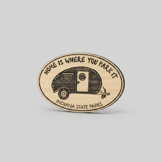 Wooden oval magnet with a camper illustration and 'Home is Where You Park It' text on a wooden surface