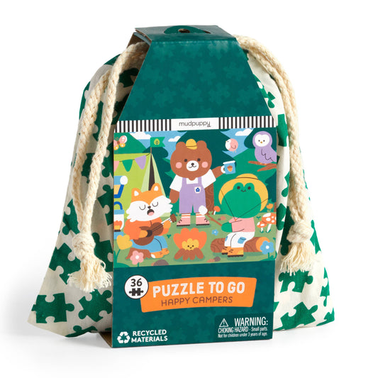 Puzzle packaging with 'Happy Campers' theme and drawstring bag on a white background