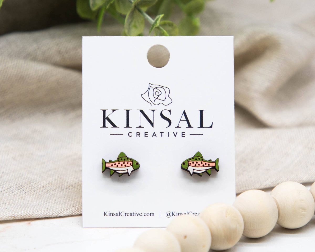 fish earrings on a white card with a beige background