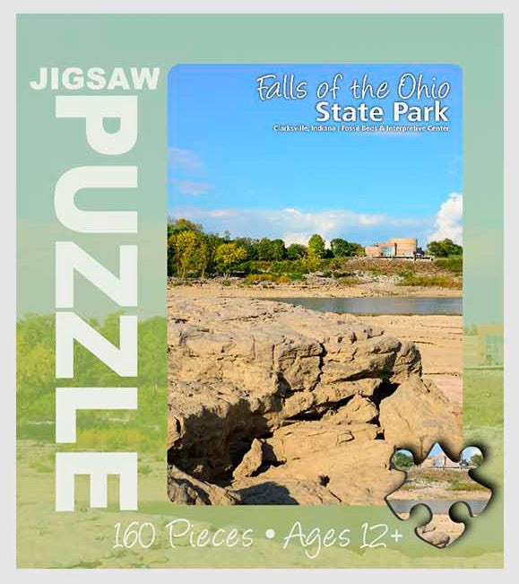 Jigsaw puzzle packaging for Falls of the Ohio State Park with scenic view and text.
