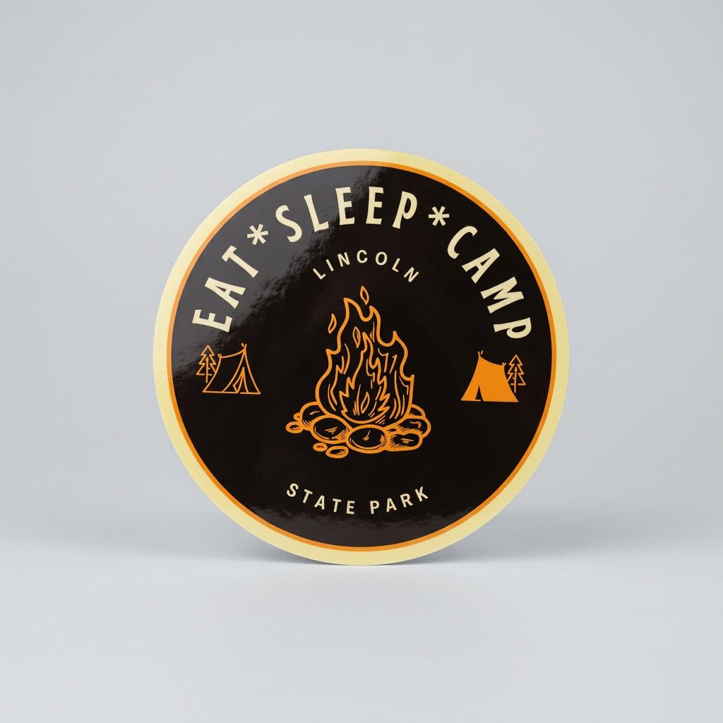 Round sticker with a campfire illustration, small tent icons, and the text “Eat • Sleep • Camp — Lincoln State Park.”
