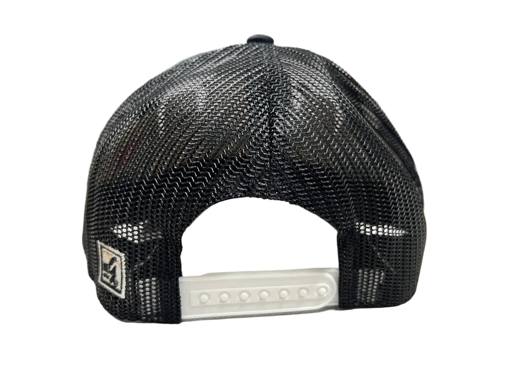 Black mesh cap on a white surface with a blurred office background