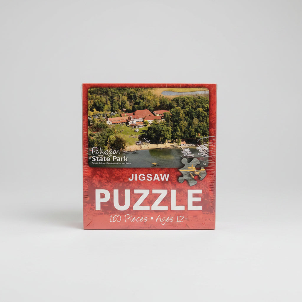 Jigsaw puzzle box with scenic image and text on a neutral background