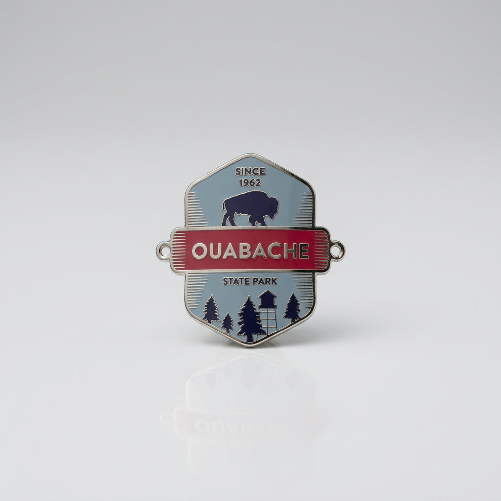 Enamel‑style hiking medallion with a bison silhouette, red banner reading “Ouabache,” and a forest and fire‑tower scene labeled “State Park.”