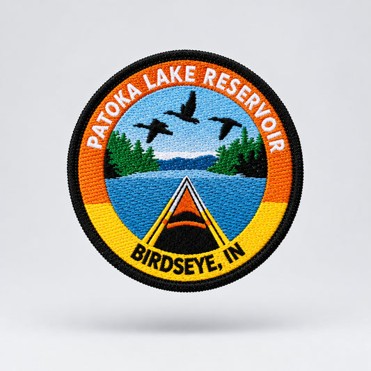 embroidered patch featuring a kayak on a lake with birds flying over head