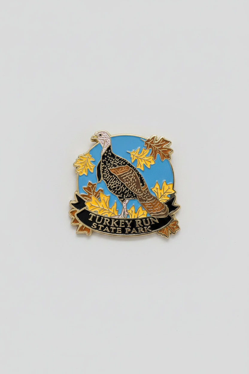 magnet with a turkey design on a blue background with yellow leaves, on a white surface.