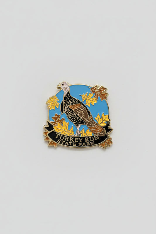 magnet with a turkey design on a blue background with yellow leaves, on a white surface.