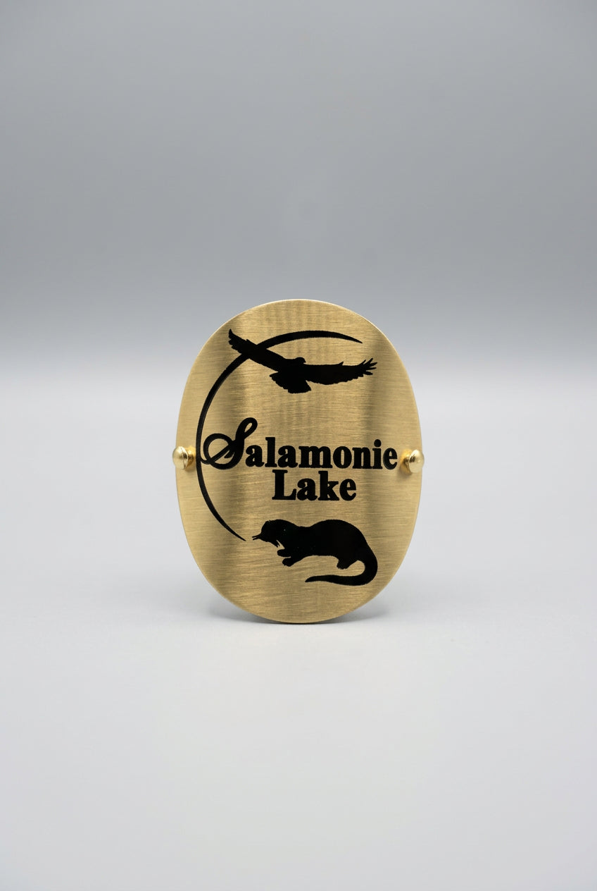 Brass‑tone hiking medallion with black silhouettes of a bird in flight and an animal, along with the text “Salamonie Lake.”