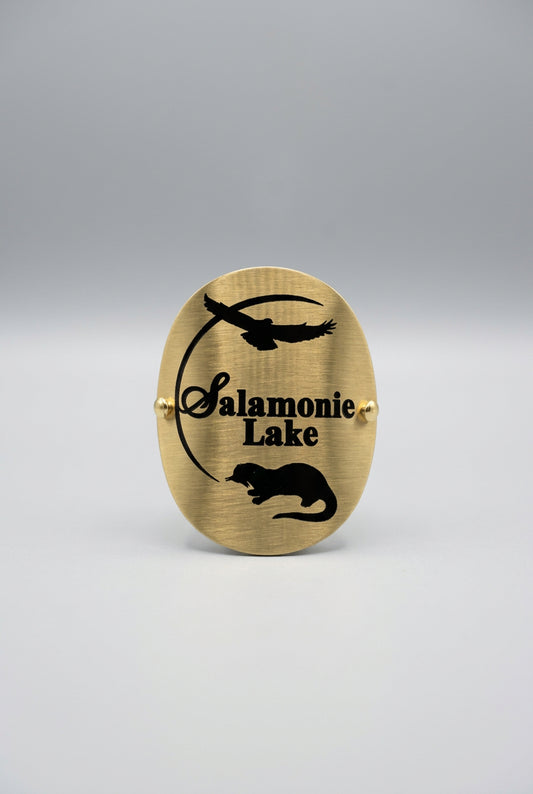 Brass‑tone hiking medallion with black silhouettes of a bird in flight and an animal, along with the text “Salamonie Lake.”