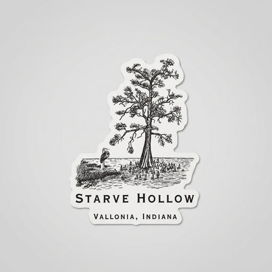 Black‑and‑white die‑cut sticker showing an illustrated tree by the water with surrounding vegetation and the text “Starve Hollow, Vallonia, Indiana.”