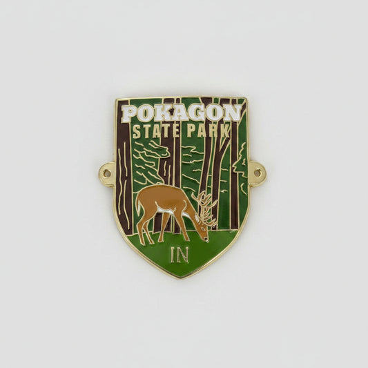 Hiking stick medallion with Pokagon State Park design featuring a deer and forest scene on a white background