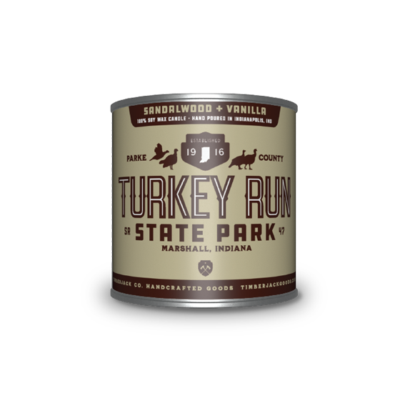 A cylindrical metal tin with Turkey Run State Park label, Sandalwood and Vanilla candle scent, featuring a tan and dark brown label, set against a plain white background.