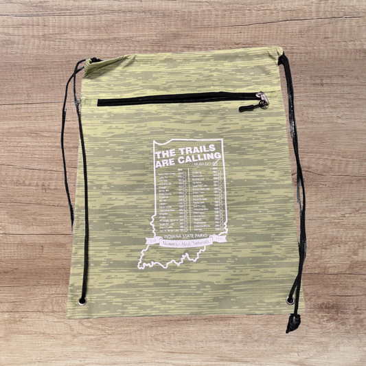 Green drawstring bag with white text on a wooden surface