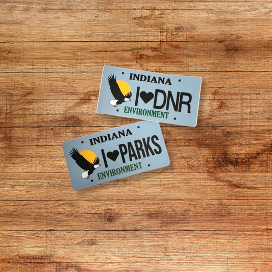 two blue indiana environment stickers on a wooden background