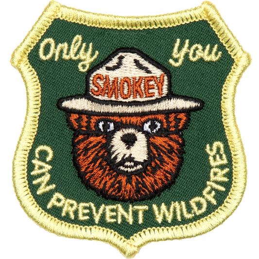 Embroidered patch with Smokey the Bear and text 'Only you can prevent wildfires' on a green background.