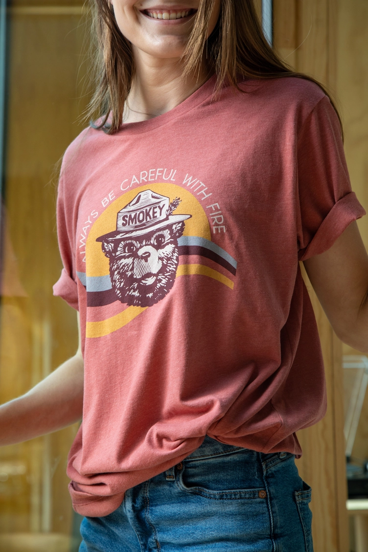 Person wearing a red t-shirt with a Smokey Bear graphic