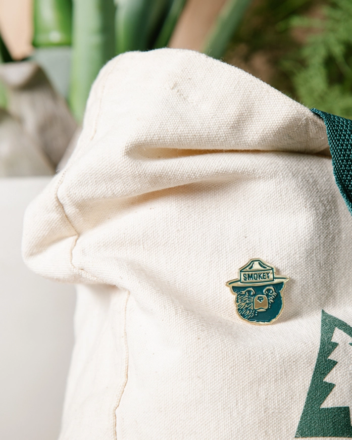  enamel pin featuring a bear design and 'Smoky' branding.