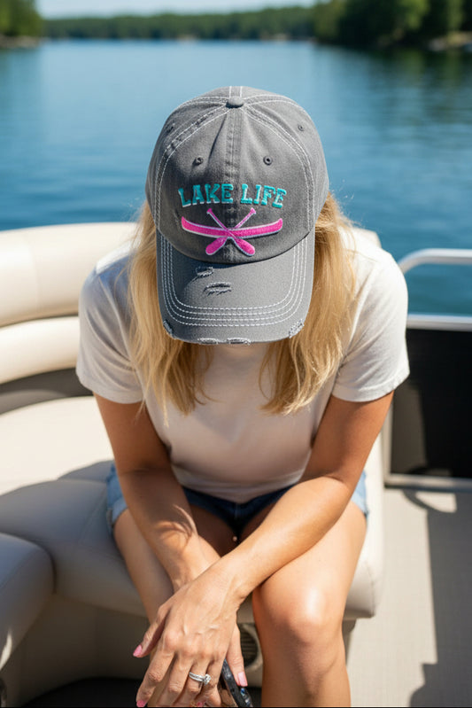 Gray distressed cap with 'Lake Life' and pink oars design worn by a model