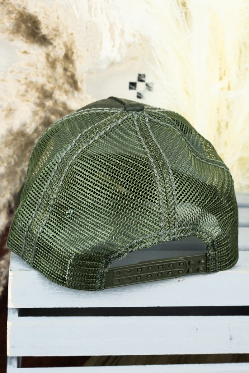 Green mesh cap on a white surface with a textured brown background
