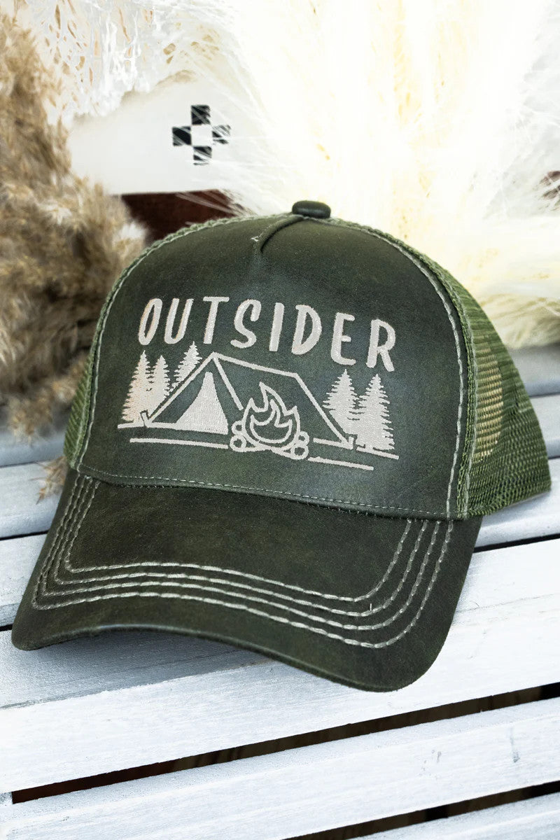 Green cap with 'Outsider' and camping graphic on a wooden surface