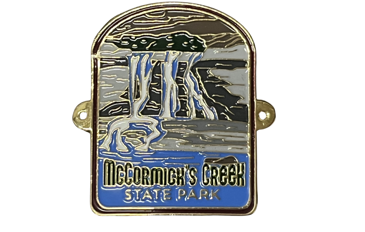 Hiking stick medallion with illustration of a waterfall and 'McCormick's Creek State Park' text on a white background