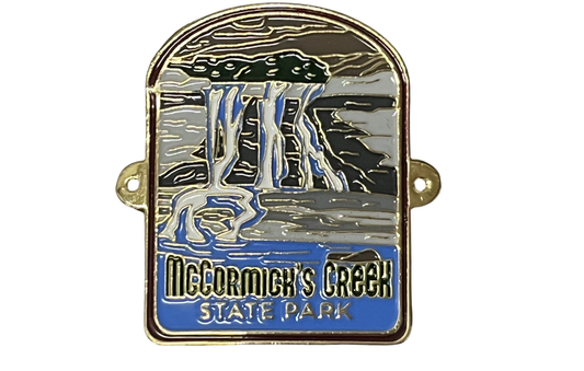 Hiking stick medallion with illustration of a waterfall and 'McCormick's Creek State Park' text on a white background